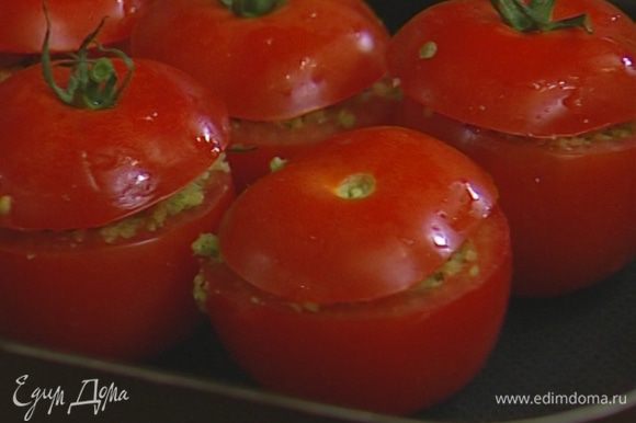 Наполнить помидоры хлебной начинкой, уложить их в небольшой противень, накрыть «крышечками» и отправить в разогретую духовку на 15–20 минут.