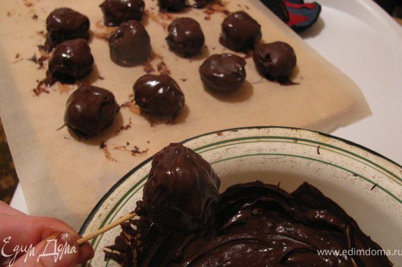 Растопить шоколад. Окунуть каждый шарик в растопленный шоколад и оставить застывать.