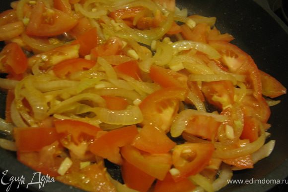 Лук порезать полукольцами и жарим в той же сковороде до золотистого цвета. Добавить нарезанные небольшими пластинками помидоры, измельченный чеснок и рубленную зелень петрушки.