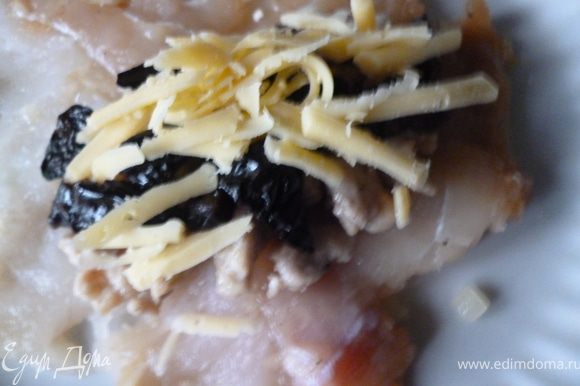 На отбитый кусок рыбы выкладываем мясную начинку,затем чернослив и сверху щепоть тертого сыра.