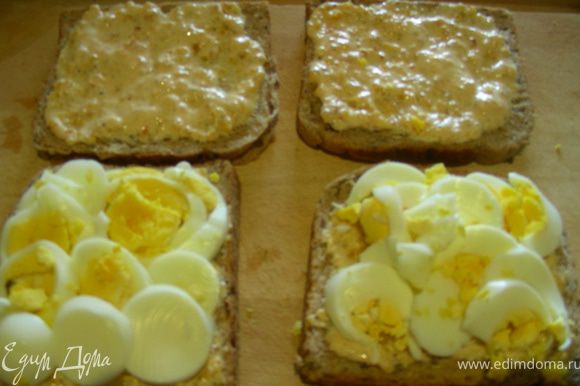 Яйца рубим или нарезаем кружочками (мне так больше нравится, они не высыпаются). Намазываем йoгуртовую смесь на хлеб (на 2 или на 4), затем выкладываем яйца и накрываем вторым кусочком.