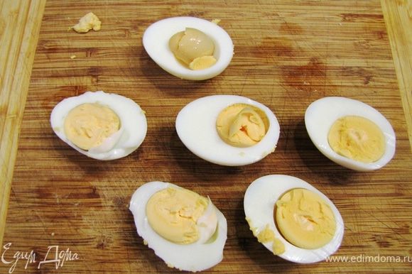 Разрежьте пополам яйца.
