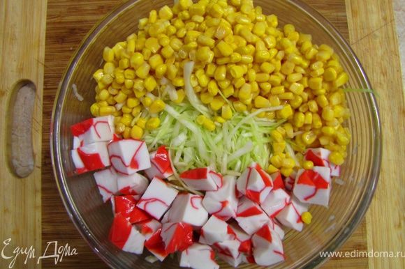 Откройте банку с кукурузой. Сок из банки выпейте , кукурузу вместе с крабовым мясом положите в емкость для салата.