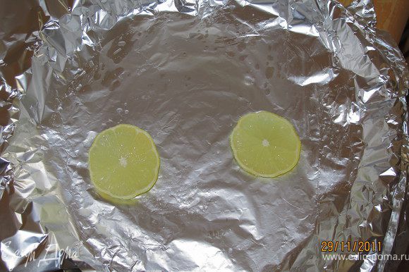 Фольгой застилаем форму, смазываем маслом и кладём два кусочка лимона.