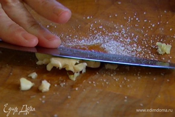 Чеснок почистить, раздавить плоской стороной ножа и растереть с солью.