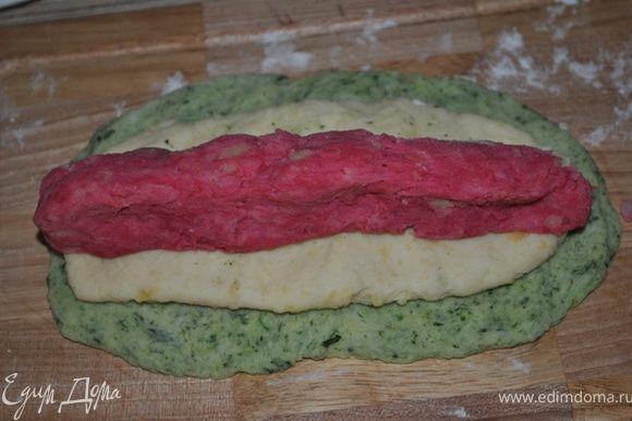 Берем оставшееся тесто. Из зеленого делаем тонкую лепешку, сверху кладем белую лепешку, поменьше размером, и в центр красную.