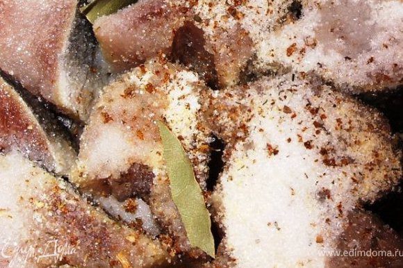 Тушки сельди помыть и порезать на 1.5 см кусочки. Сложить их в маленькую кастрюльку или мисочку. Лавровые листья поломать на 3-4 частицы и положить между кусочками рыбы. Посыпать сверху хмели-сунели, сухой чеснок, сахар и соль.