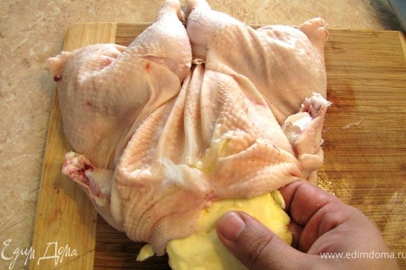 В принципе такой способ разделывания курицы "прячет" грудку посередине и она будет защищена от лишнего жара, но для лучшей защиты от пересушивания мы положем сливочное масло на грудку под кожу. Отделите кожу от грудки. Кожа к грудке практически не прикреплена, поэтому вы легко это сделаете, просунув пальцы под кожу. Разомните масло и придайте ей форму, аналогичную грудке. Засуньте масло под кожу и разровняйте его. Убедитесь, что масло не съедет в сторону.
