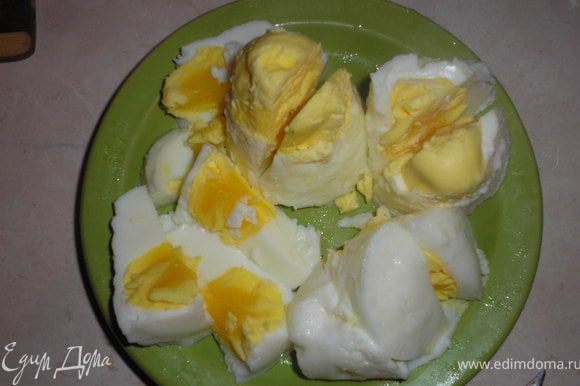 Свареные яйца вынимаем и разрезаем на 4 куска.