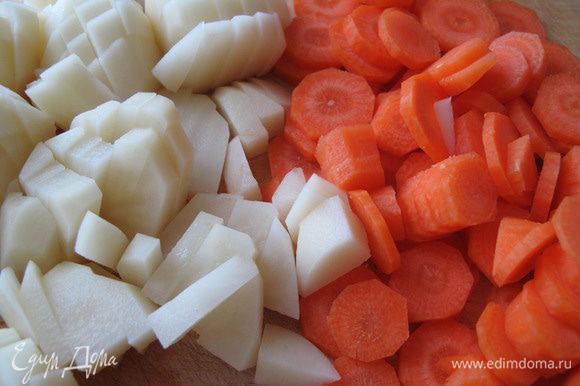 Опустите почищенную порезанную морковь в кастрюлю с кипящей водой, через 3 минуты добавьте туда картошку. Посолите.