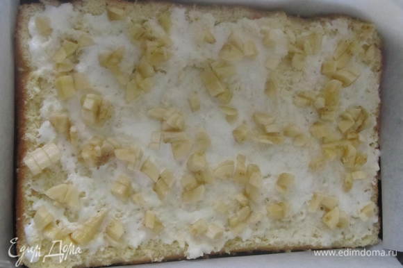 Белый бисквит положить на дно формы,полить сверху растопленным мороженым, посыпать нарезаным бананом.