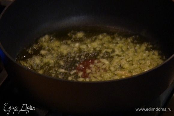Разогреть в сковороде оливковое масло и обжарить лук и чеснок до прозрачности.
