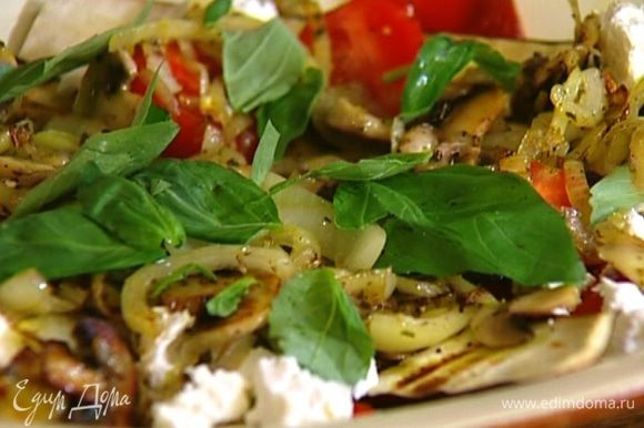 Готовые грибы с луком выложить сверху на салат, сбрызнуть все оливковым маслом и украсить листьями базилика.