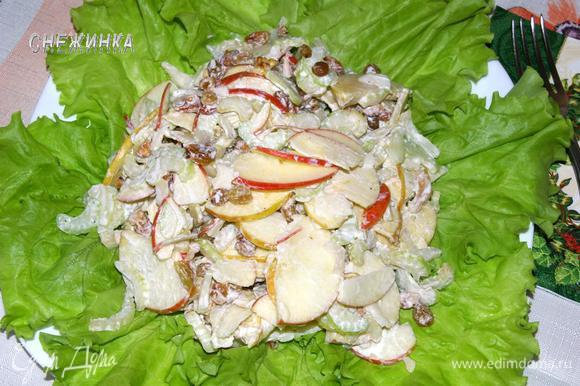 На плоское блюдо уложить листья салата, сверху положить заправленный салат и можно подавать.