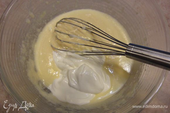 Положите в получающееся тесто сметану и хорошенько взбейте. Не волнуйтесь, если вам покажется, что тесто свернулось. После добавления муки текстура восстановится.