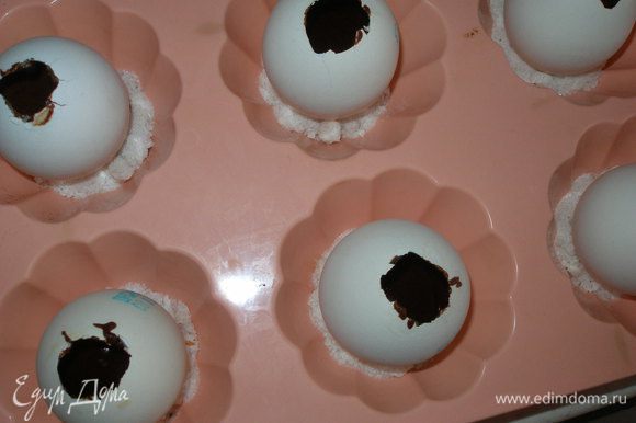 Заранее приготовленные скорлупки яиц поставить в формы для маффинов, куда предварительно насыпать немного соли, чтобы "яйца" не упали. Заполнить пустые скорлупки яиц тестом где-то на 3/4 (не больше) объема. Выпекать при 180С около 15 минут. "Яйца" полностью остудить и только потом их можно чистить.