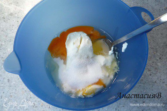 Творог перемешать со сметаной, 2 яйцами, 75г сахара и лимонной цедрой. Добавить ванильный сахар. Разогреть духовку до 175°C.
