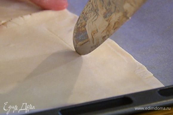 Противень выстелить бумагой для выпечки, выложить тесто и на каждом пласте, отступая на 2 см от края, ножом прочертить квадрат, не прорезая тесто до конца, чтобы получились бортики.