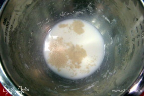 В большой ёмкости смешать воду и молоко (их температура не должна быть выше 26°С) с сахаром и дрожжами.