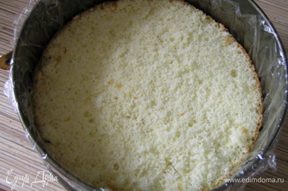 Застелить разъемную форму для торта пищевой пленкой, на дно выложить бисквитный корж.