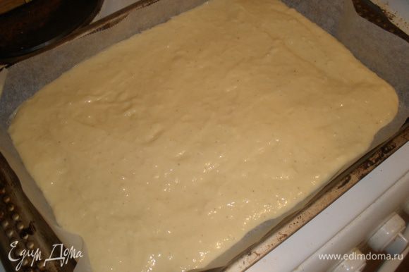 Противень застелить пекарской бумагой, выложить тесто и разровнять.