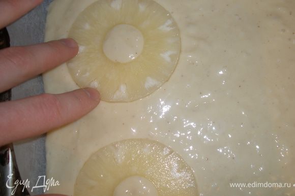 С ананасов слить воду, выложить их на тесто,слегка вдавливая в него.