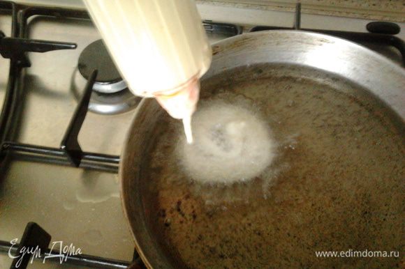 Теперь разогреваем масло в сковороде и с помощью кондитерского шприца выдавливаем спиралькой,как бы закручивая тесто опускаем во фритюр