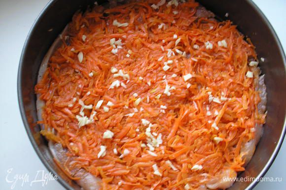 Выкладываем на куриное филе морковь. Морковь посыпаем рубленым чесноком.