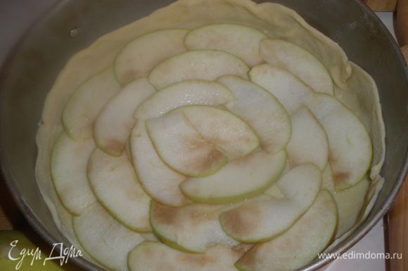 1/3 часть яблок нарезаем на очень тонкие слои и сразу же укладываем на тесто. Я специально не стала заранее резать,чтобы не потемнели. Сверху посыпаем 1/3 части сахара.