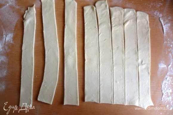 Раскатать слоеное тесто толщиной 3-4 мм. и нарезать длинные тонкие полоски