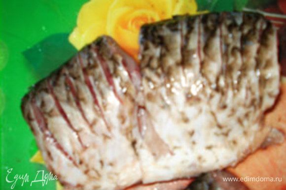 На каждом кусочку со стороны спинки сделать надрезать глубиной 0,5-1 см.Надрезы делать как можно чаще.Это необходимо, так как речная рыба, особенно карась, очень костлявая. Надрезы при жарке и дальнейшем запекании размягчают их и при еде не чувствуются.