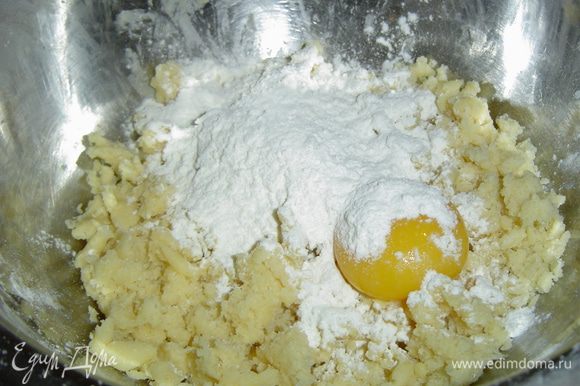 к полученной крошке добавляем яичный желток, ванильный сахар, остаток муки и замешиваем тесто.