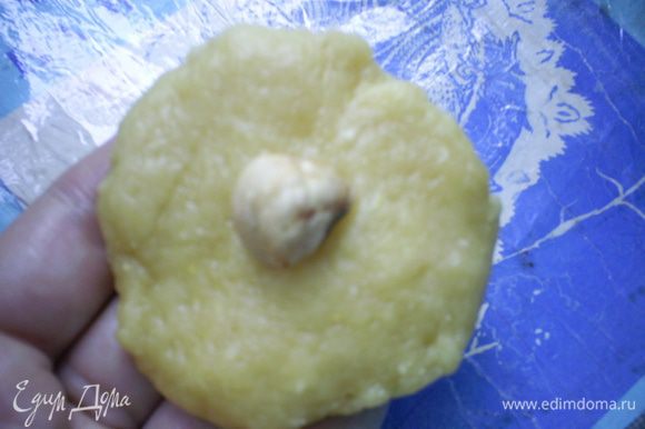 Берем кусочек теста размером с грецкий орех, расплющиваем его и кладем в серединку орешек или несколько изюминок.