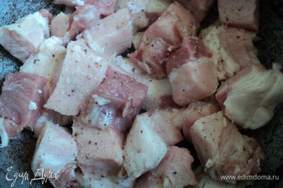 Мясо порезать кусочками 3 х 3 см, немного сала порезать пластинками. На дно казана положить пластинки сала, сверху мясо. Посолить и поперчить.