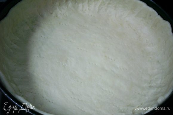 Тесто раскатываем и переносим в разъемную форму диаметром 26 см, формируя бортики. Стенки и дно формы предварительно слегка смазываем растительным маслом. Накалываем тесто вилкой.
