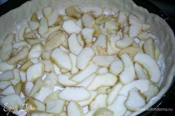 Тесто посыпаем крахмалом и выкладываем яблоки, почищенные и порезанные тонкими дольками.