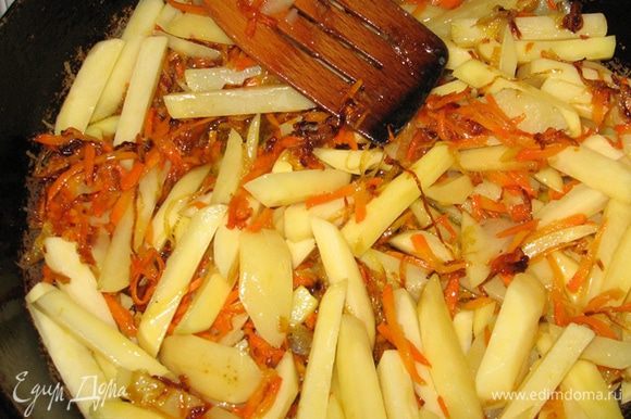 Картофель нарежьте соломкой и выложите на сковороду к луку и морковке. Жарьте их вместе, помешивая, минут 5.