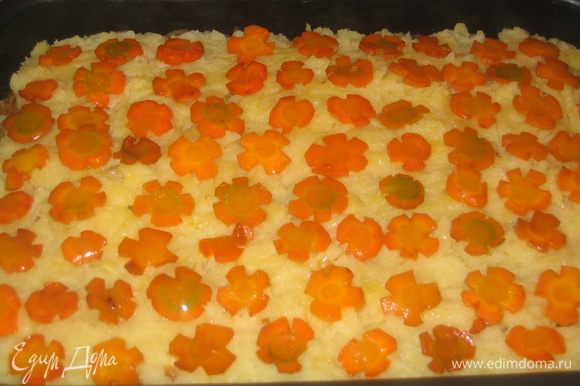 Выложить слой оставшегося картофельного пюре, на него разложить морковь.
