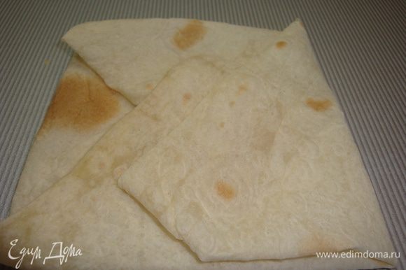 Лаваш нарезаем на квадраты, свернуть конвертиком и уложить в формы, выстланный бумагой для выпечки.