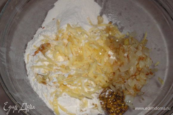 Лук нарезаем кубиком и обжариваем до золотистого цвета на растительном масле. Сыр натираем на крупной терке, добавляем мягкое сливочное масло, горчицу, муку, разрыхлитель, перец, соль.