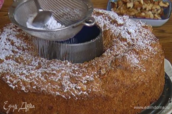 Готовый пирог посыпать сахарной пудрой и украсить оставшимися орехами.