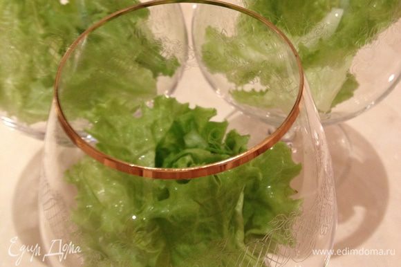 Положить листья салата на дно бокала