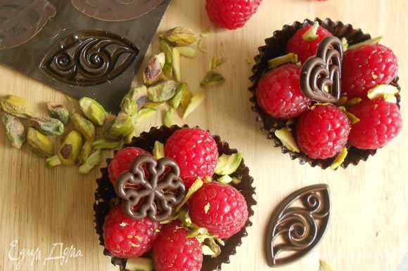 Выложить ягоды в корзинки, посыпать фисташками, при желании украсить готовыми шоколадными фигурками.