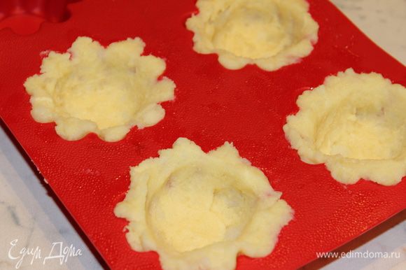 В формочки для кексов, смазанные маслом, выложить (по 1 ст.л. с горкой) картофельное пюре и распределить его по краям, как корзиночки