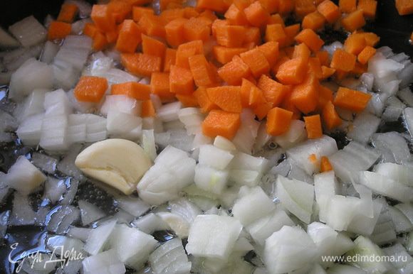 В смеси растительного и сливочного масел обжарить на медленном огне нарезанный лук, слегка придавленный зубчик чеснока и нарезанную кубиками морковь.