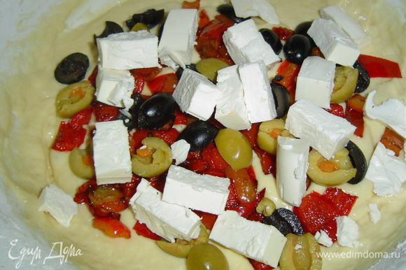 В тесто добавляем остывший перец, нарезанную кубиками фету, разрезанные пополам маслины и оливки.