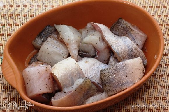 Сложите рыбу в керамическую форму. Полейте сверху растительным маслом. и хорошо перемешайте рыбу.