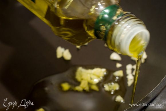 В глубокую сковороду налить оливковое масло и спассеровать в нём зубочки чеснока.