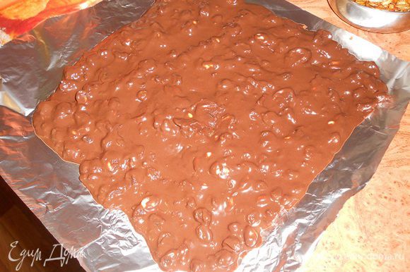 Растопить шоколад(60 г) для кранча, добавить к нему масло(45г) и сливки(100г), перемешать, добавить изюм и орехи, а также какао(3 ст.л.), перемешать и поставить на 5 минут в морозилку, затем достать и выложить на лист фольги, разровнять по размеру формы, в которой будете собирать торт, поставить фольгу с кранчем в холодильник.