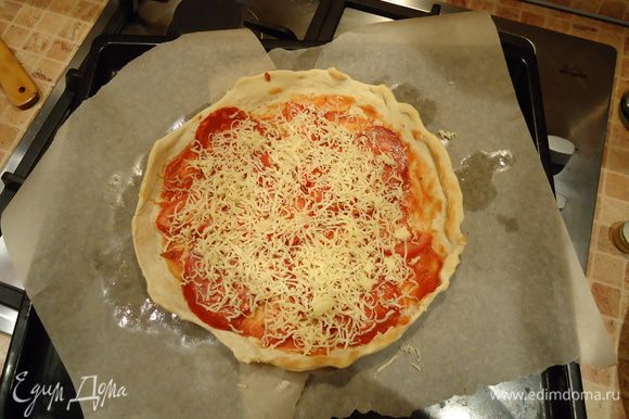 Дальше укладываем начинку: соус, колбаса, ломтики помидора, сыр. И запекаем до готовности примерно 12-15 мин. Готовую пиццу приправить орегано и тимьяном.